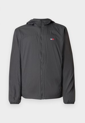 Lahka črna vetrovka z zadrgo, kapuco na vrvico, elastičnimi zapestji in majhnim blagovnim znakom na prsih.