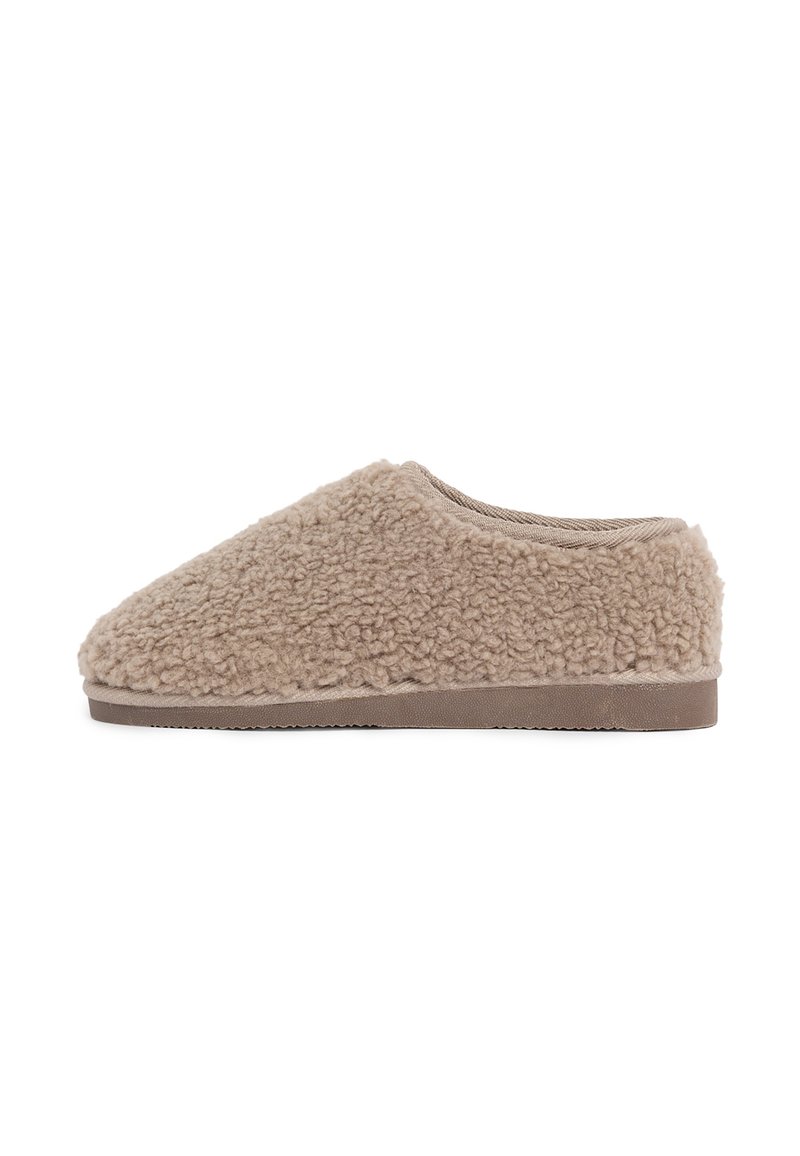 Beige instapslipper met een zachte, krullende fleece bovenkant en een platte rubberen zool, ontworpen voor binnencomfort.