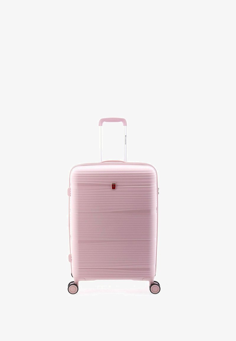 Maleta rosa de material rígido con textura estriada, asa retráctil, ruedas dobles y un logo rojo en la parte frontal. Diseño compacto y ligero.