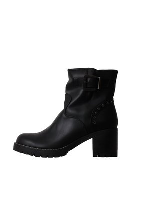 Bottine noire en cuir avec talon bloc, bride à boucle près du haut, et clous décoratifs en métal sur le côté.