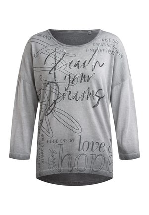 Light gray long-sleeve shirt with sequin text "Reach your dreams" and printed words like "hope," "love," and "good energy" in various fonts.