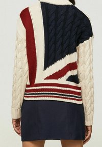 Kabelstrickpullover mit einem Union Jack-Design in Marineblau, Rot und Creme. Detaillierter gerippter Saum und Bündchen. Strukturierte Strickmuster.