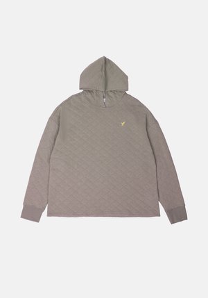 Siva prošivena dukserica s kengurujim džepom i visokim ovratnikom. Ima mali žuti logo na prsima i rebraste manžete.