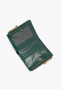 Donkergroene leren portemonnee geopend om het doorzichtige ID-vak, vier kaartvakken, drukknoop en gouden rits te tonen, gelabeld met Kurt Geiger echt leer.