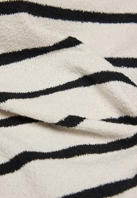 Cream fabric with horizontal black stripes, showing a textured, slightly wrinkled surface.