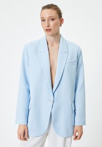 Blazer azzurro chiaro realizzato in tessuto liscio, con chiusura a un bottone, rever a pattina e taschino sul petto, dal design slim fit.
