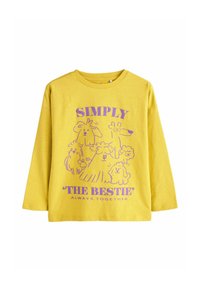 Kollane pikkade varrukatega T-särk, millel on lilla graafika karikatuurkoertest ja tekst "SIMPLE BESTIE ALWAYS TOGETHER." Pehme tekstuur.