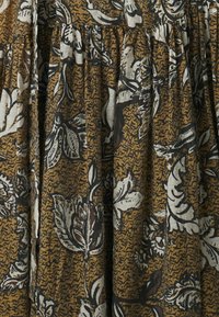 Brown floral fabric with white and black botanical patterns; textured surface with gathered sections, creating a layered appearance.