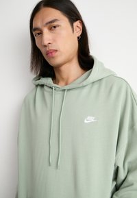 Nike Sportswear CLUB OVERSIZED - Džemperis ar kapuci - jade horizon/white