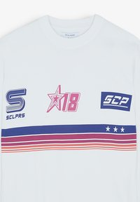 Camiseta de algodón blanca de manga larga con diseños gráficos en azul, rojo y rosa, incluyendo texto y rayas en el pecho.