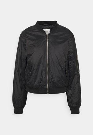 Blouson bomber léger noir avec fermeture éclair frontale, col, poignets et bas côtelés, deux poches latérales et une poche zippée sur la manche gauche.