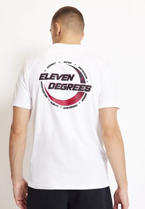 Camiseta blanca de algodón con un gran gráfico circular en la parte posterior que dice "ELEVEN DEGREES" en negro y rojo, junto con nombres de ciudades en negro.