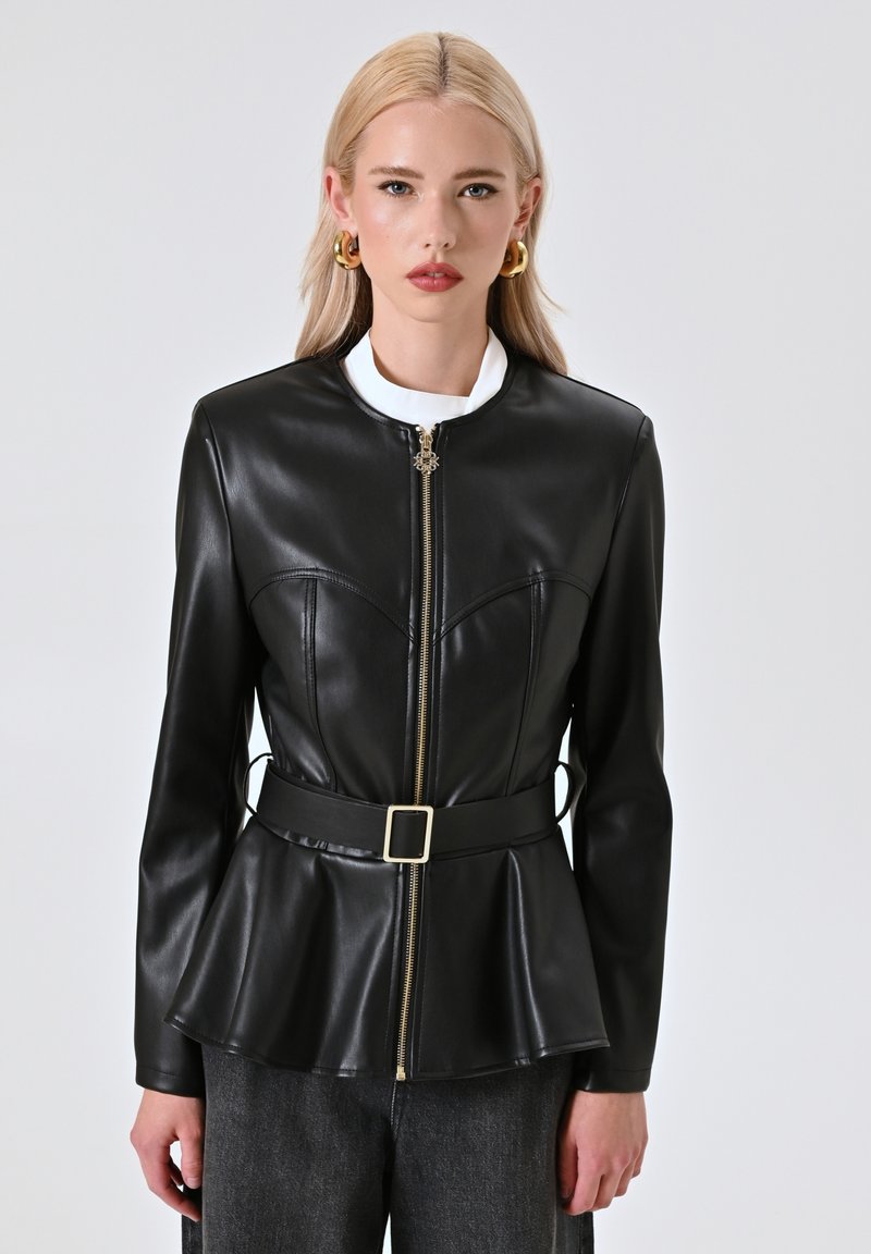 Giacca in finta pelle nera con un corpo aderente, chiusura con zip, orlo a peplum e una cintura con fibbia quadrata. Presenta un colletto alto e una texture liscia.