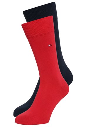 Deux paires de chaussettes mi-hautes : une rouge uni et une bleu marine uni. Chaque chaussette présente une bordure côtelée et un petit logo sur la cheville.