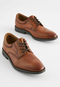 Chaussures habillées en cuir marron avec une finition lisse, design à lacets, bouts ronds et semelles en caoutchouc noir. Coutures détaillées le long des coutures.