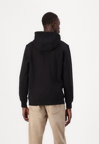 Schwarzer Kapuzenpullover mit lockerer Passform, gerippten Bündchen und Saum, glatter Textur und ohne sichtbare Logos oder Muster.