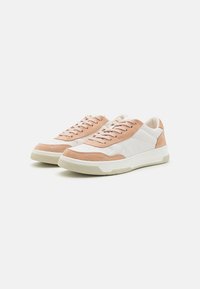 Sneakers con tomaia in pelle bianca e camoscio pesca, lacci piatti, dettagli perforati e suola in gomma beige texturizzata.