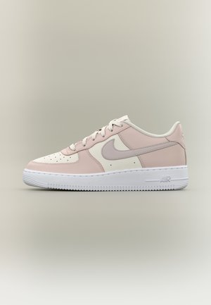 Nízký model tenisek Nike Air v světle růžové, bílé a béžové barvě s bílými tkaničkami a bílou podrážkou na neutrálním pozadí.