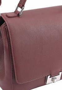 Leren handtas in mauve, met een gladde textuur, een magnetische klep sluiting, zilverkleurige hardware en contrasterende stiksels.