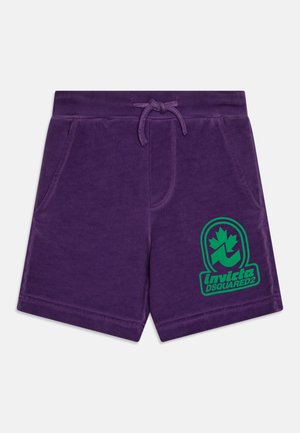 Lila Shorts aus weichem Stoff, mit einem Kordelzugbund, zwei Seitentaschen und einem grünen Logo auf dem linken Oberschenkel.