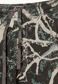 Grafiske sorte og grå sweatpants med et mønster af grene i teal. Inkluderer en justerbar talje med snøre og blødt bomuldsmateriale.