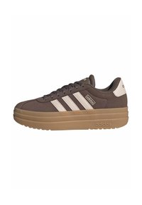 Brown Adidas sneaker with thick tan sole, white heel tab, and three white side stripes, shown from the outer side.