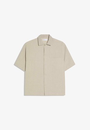 Rövid ujjú ing világos bézs lenvászonból. Elöl gombos, hegyes gallérral és egyetlen mellzsebbel. Simább tapintású anyag.