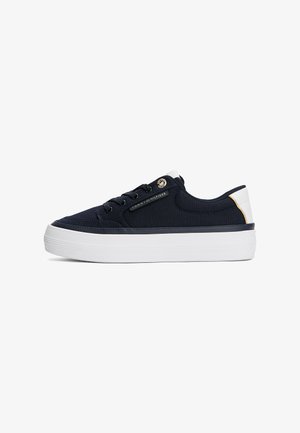 Sneaker in tela blu navy con suola in gomma bianca, dettagli oro e occhielli. Presenta un design con lacci e un dettaglio con logo sul lato. Forma a profilo basso.