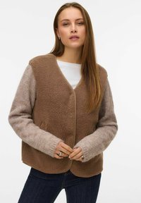 Brown fleece vest with a textured body and light gray knit sleeves. Features a rounded neckline and simple button closure.