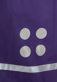 Purple fabric with three silver glitter circles arranged vertically and a horizontal silver ribbon near the bottom.