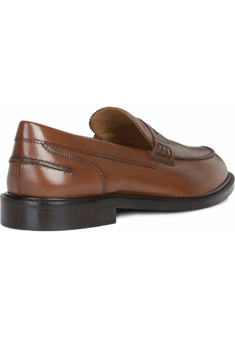 Brązowy skórzany but wsuwany z okrągłym noskiem, przeszyciami i niską czarną gumową podeszwą. Gładkie wykończenie z minimalnymi akcentami.