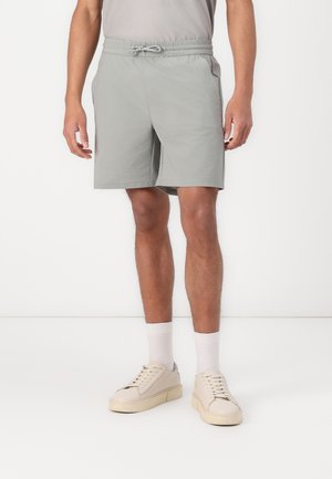 Light grey shorts with an elastic waistband and drawstring. Features side pockets, casual fit, and smooth fabric texture.