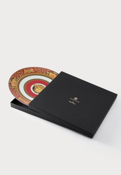 Versace decorative plate in a black box, featuring vibrant red and gold circular patterns, with a central design in a glossy white finish.