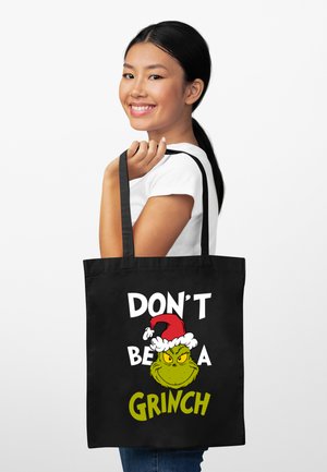 Borsa tote in tela nera con un cartone animato del Grinch con un cappello da Babbo Natale rosso e testo audace in bianco e verde: "NON ESSERE UN GRinch."