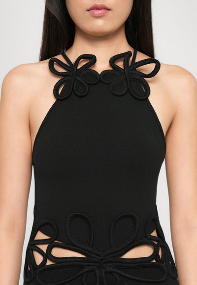 Top negru tip halter cu modele florale texturate la decolteu și talie, cu laterale decupate. Fabricat dintr-un material elastic și adaptat corpului.