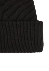 Gorro de punto negro con textura acanalada, un puño doblado y un ajuste ceñido. Hecho de material suave y elástico para mantener el calor.