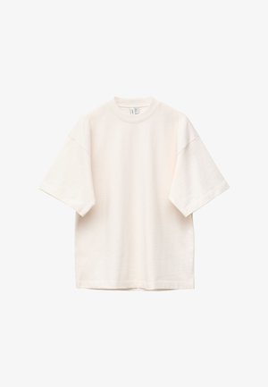 Übergroßes, kurzärmeliges T-Shirt in Cremefarbe mit Rundhalsausschnitt, lockerem Sitz und sichtbaren Nähten an Ärmeln und Schultern.