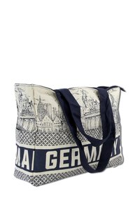 Canvas draagtas met een geborduurd ontwerp van Duitse bezienswaardigheden in het zwart op een crème achtergrond, met marineblauwe handvatten en accenten.