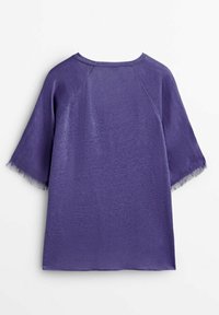 Haut violet à manches courtes avec une finition douce et texturée et un détail de franges le long de l'ourlet et des manches. Coupe décontractée avec un col rond.