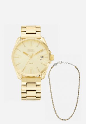 Goldfarbener Metallarmbanduhr mit rundem Ziffernblatt, minimaler Markierung, Datumsanzeige und einem Gliederarmband. Daneben ein dünnes zweifarbigen Kettenarmband.