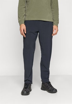 Pantalon léger bleu marine à coupe droite, associé à un haut à manches longues vert olive. Présente une texture lisse et un design minimaliste.
