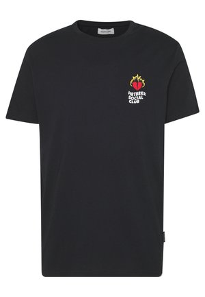 T-shirt en coton noir avec des manches courtes, un col rond, et un imprimé graphique d'un cœur avec des flammes et du texte sur le côté gauche de la poitrine.