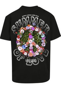 Sort bomulds T-shirt med et blomstret fredstegn design. Teksten inkluderer "SUMMER OF LOVE" og "kærlighed kommer med fred" i hvid.