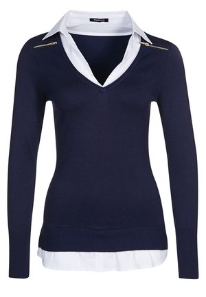 Navy knit sweater with a V-neck and long sleeves, layered over a white collared shirt. Features a gold zipper accent on the shoulder.