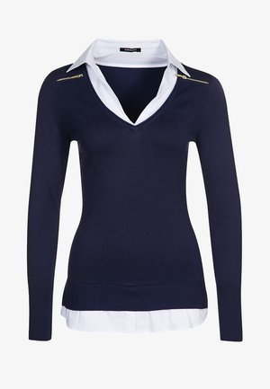 Navy knit sweater with a V-neck and long sleeves, layered over a white collared shirt. Features a gold zipper accent on the shoulder.