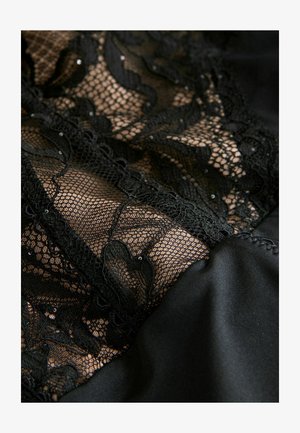 Juodas nėrinių audinys su gėlių raštais, išdėstytas ant lygios juodos satino bazės, su smulkiais detalėmis ir tekstūruota išvaizda.