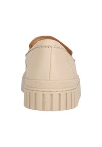 Beige faux lädersneakers med rund tå och texturerad gummisula. Har lätt sömnad och en slät finish, samt en vadderad krage.