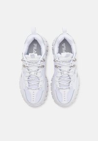 Baskets de sport blanches avec un dessus en maille, design texturé, semelle en caoutchouc et accents métalliques. Elles disposent de lacets et d'un logo sur la languette.