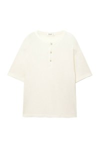 Cream-colored short-sleeve henley shirt made of textured fabric, featuring a round neckline and three buttons down the front.