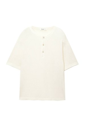 Cream-colored short-sleeve henley shirt made of textured fabric, featuring a round neckline and three buttons down the front.